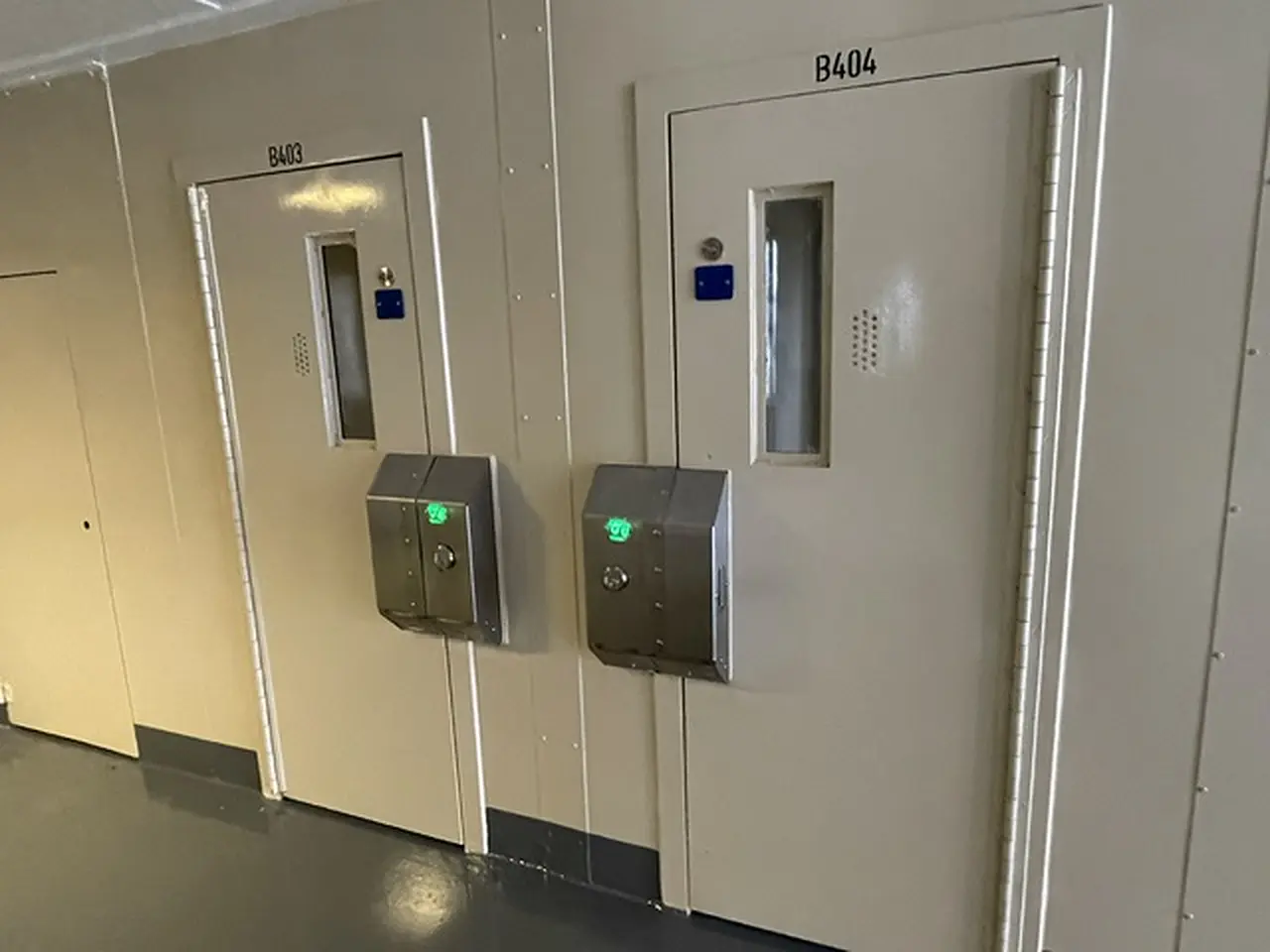 Two cell doors fitted with new stainless lock boxes showing green status lights
