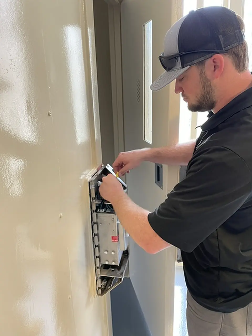 AE technician fitting a lock box to a cell door