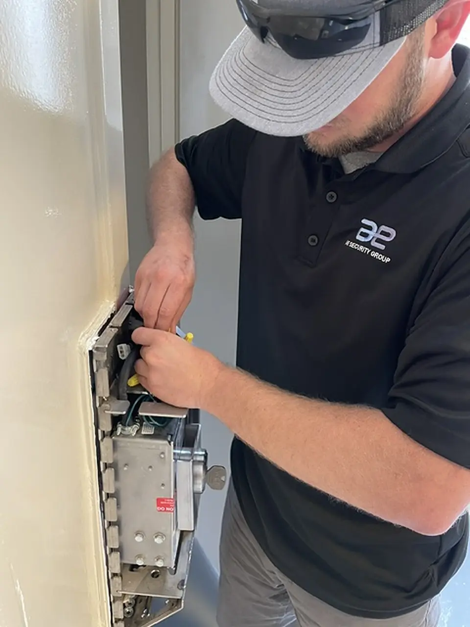 AE technician wiring a lock box on a cell door