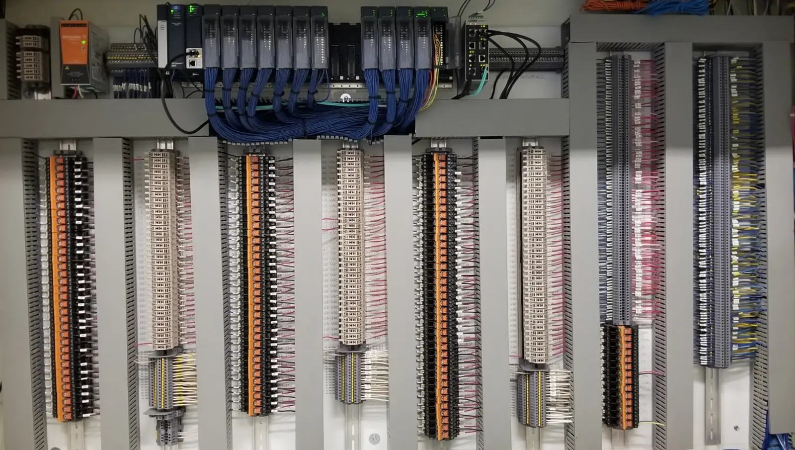 PLC racks, terminal blocks and field wiring in a locking control panel installed by AE